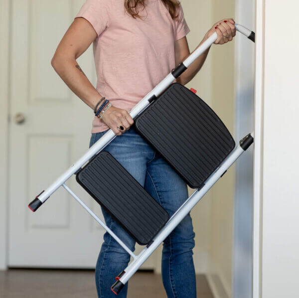 Person carrying two step ladder